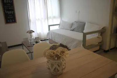 a room with a table with a bed and a vase with flowers at Dpto Downtown Nueva Córdoba, la mejor ubicación!! Sin Gastos adicionales - Cochera opcional in Cordoba