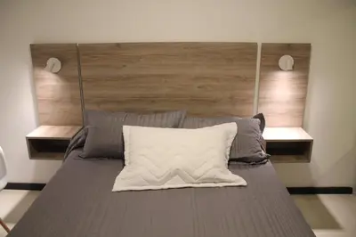 a bedroom with a large bed with a wooden headboard at Dpto Downtown Nueva Córdoba, la mejor ubicación!! Sin Gastos adicionales - Cochera opcional in Cordoba
