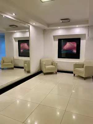a waiting room with chairs and paintings on the wall at Calidez in Villa Carlos Paz