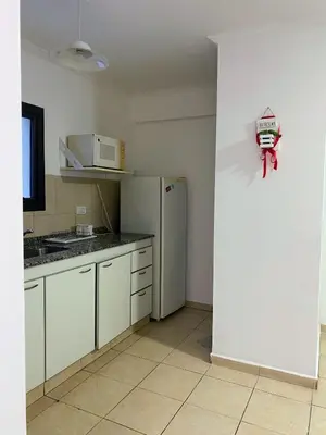 a kitchen with a refrigerator and a clock on the wall at Calidez in Villa Carlos Paz