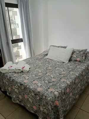 a bed with two towels on it in a room with a window at Apart salguero in Cordoba
