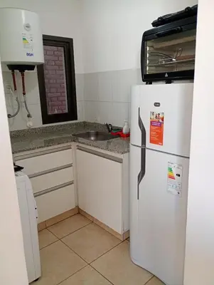 a kitchen with a white refrigerator and a sink at Apart salguero in Cordoba