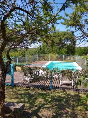 a swimming pool with a fence around it at Cabañas Rayuela y otros cuentos in Santa Rosa de Calamuchita