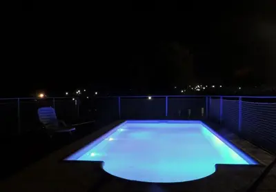 a large swimming pool lit up at night at Cabañas Rayuela y otros cuentos in Santa Rosa de Calamuchita