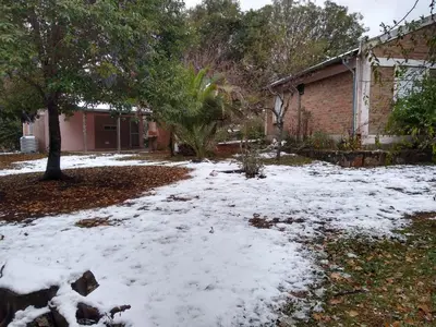 a yard covered in snow in front of a house at Cabañas Rayuela y otros cuentos in Santa Rosa de Calamuchita