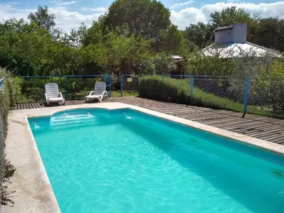 a swimming pool with two chairs in a yard at Cabañas Rayuela y otros cuentos in Santa Rosa de Calamuchita