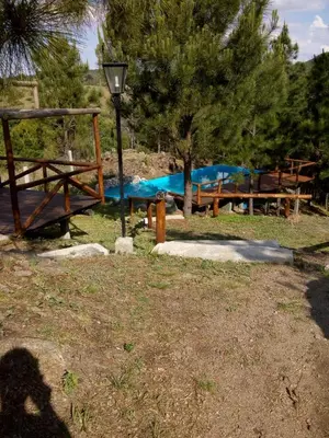 a group of picnic tables in a park with a pool at Terra Nostra in Cordoba