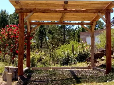 a wooden pergola in a garden with flowers at Terra Nostra in Cordoba