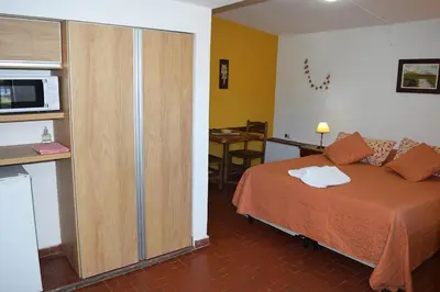 a bedroom with a bed and a cabinet with a microwave at Los Sauces Posada in Nono