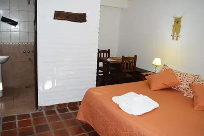 a bedroom with a bed and a bathroom with a shower at Los Sauces Posada in Nono