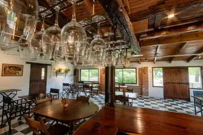 a dining room with tables and chairs and chandeliers at Los Sauces Posada in Nono