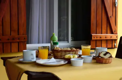 a table with a breakfast of orange juice and bread at Los Sauces Posada in Nono