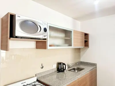 a kitchen with a microwave above a sink at PASEO QUATTRO in Villa Carlos Paz