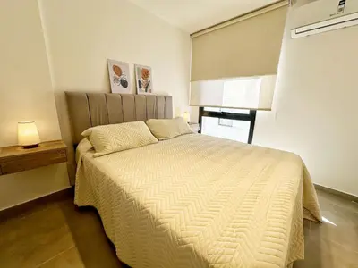 a bedroom with a bed with a white comforter at PASEO QUATTRO in Villa Carlos Paz