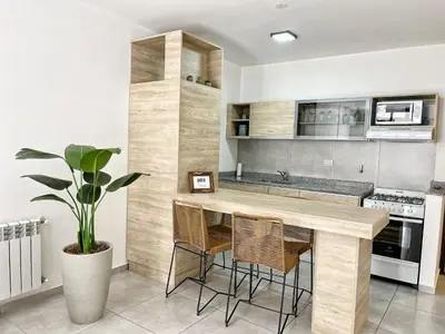 a kitchen with a wooden counter and stools at PASEO QUATTRO in Villa Carlos Paz