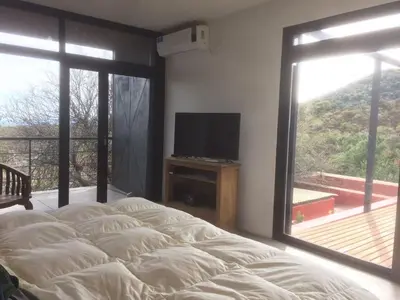 a bedroom with a large bed and a television at LUMAFACA in La Población