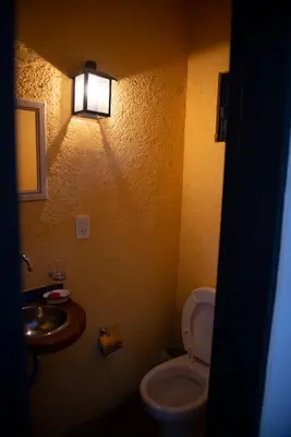 a bathroom with a toilet and a sink and a light at LUMAFACA in La Población