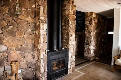 a fireplace in a room with a stone wall at LUMAFACA in La Población