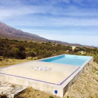 a swimming pool in a field with mountains in the background at LUMAFACA in La Población