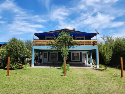 a blue house with a tree in front of it at Complejo Cielo Azul in Villa Rumipal