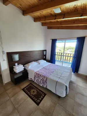 a bedroom with a bed and a large window at Complejo Cielo Azul in Villa Rumipal