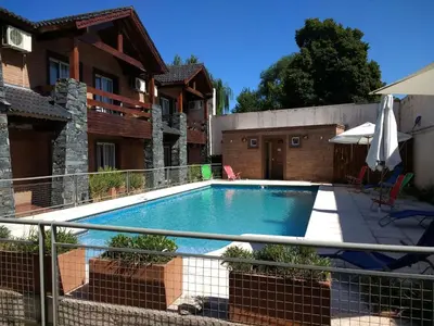 a swimming pool in the backyard of a house at Aguas Claras Hosteria in Santa Rosa de Calamuchita