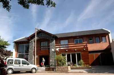 a house with a car parked in front of it at Aguas Claras Hosteria in Santa Rosa de Calamuchita