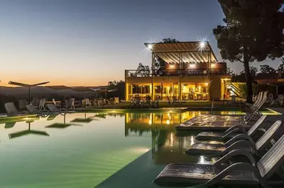a swimming pool with chairs in front of a building at Balcón del Río, Hotel de Campo y Cabañas in Mina Clavero