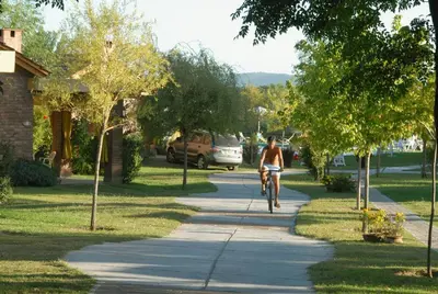 a person riding a bike down a sidewalk at Balcón del Río, Hotel de Campo y Cabañas in Mina Clavero
