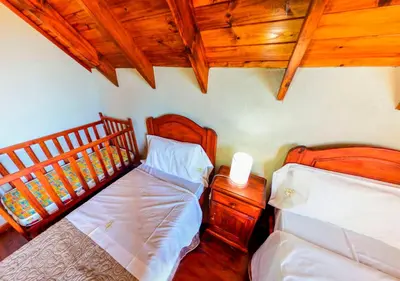 a bedroom with two beds and a wooden ceiling at Cabañas Brisas del Cerro in Los Reartes
