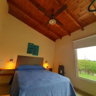 a bedroom with a bed and a ceiling fan at Piscu Yaco in Santa Rosa de Calamuchita