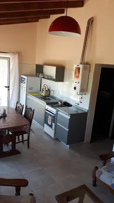 a kitchen with a stove and a table with a tableablish at Piscu Yaco in Santa Rosa de Calamuchita