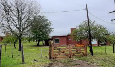 a barn with a wooden gate in a field at Piscu Yaco in Santa Rosa de Calamuchita