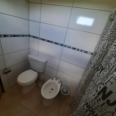 a small bathroom with a toilet and a sink at Piscu Yaco in Santa Rosa de Calamuchita