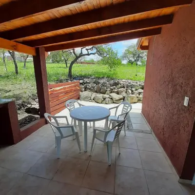 a white table and chairs on a patio at Piscu Yaco in Santa Rosa de Calamuchita