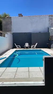 a swimming pool with two chairs and a table at Doña Aida in Mina Clavero