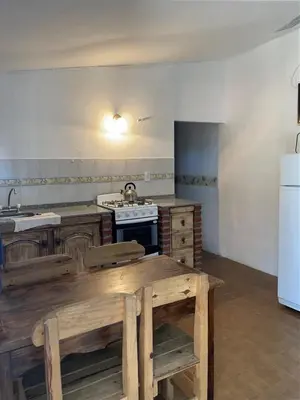 a kitchen with wooden tables and a white refrigerator at Doña Aida in Mina Clavero