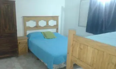 a bedroom with two twin beds and a dresser at Doña Aida in Mina Clavero