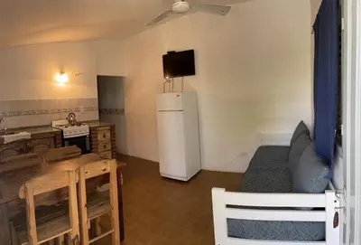 a living room with a refrigerator and a table at Doña Aida in Mina Clavero