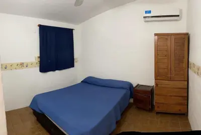 a bedroom with a blue bed and a wooden cabinet at Doña Aida in Mina Clavero
