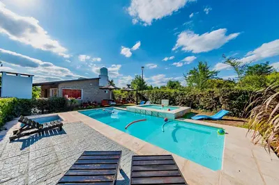 a swimming pool in a yard with two loungers at La Querencia in Villa Carlos Paz
