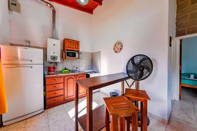 a kitchen with a refrigerator and a table and chairs at La Querencia in Villa Carlos Paz