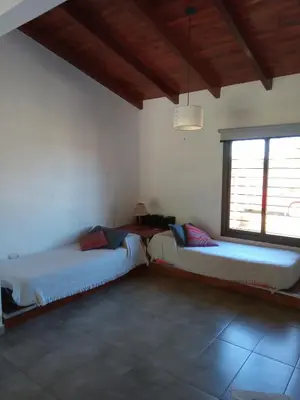a room with two beds and a window at Cabaña Azul in Villa Anizacate