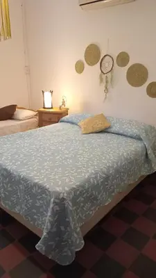 a bedroom with a bed and a clock on the wall at La Guadalupana in Mina Clavero