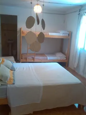 a bedroom with two bunk beds with white sheets at La Guadalupana in Mina Clavero