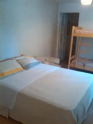 a bedroom with a large white bed and a ladder at La Guadalupana in Mina Clavero