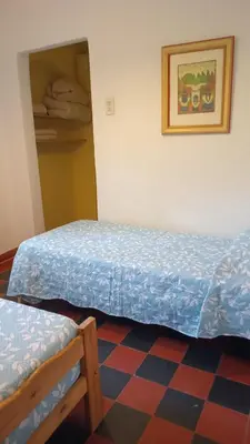 a bedroom with two beds and a checkered floor at La Guadalupana in Mina Clavero