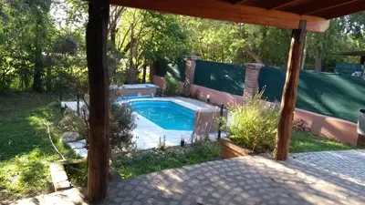 a swimming pool in a backyard with a pergola at Complejo Norte in Merlo