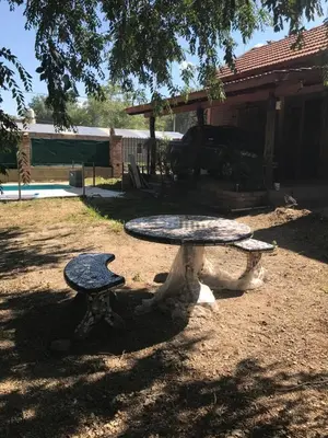 a stone table and bench in a yard at Complejo Norte in Merlo
