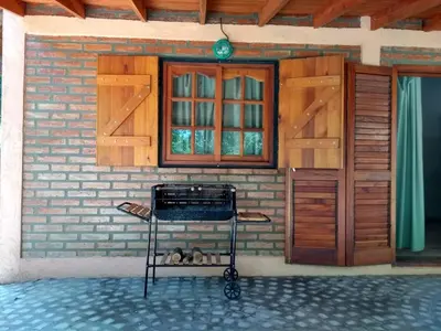 a barbecue grill in front of a building with doors at Complejo Norte in Merlo